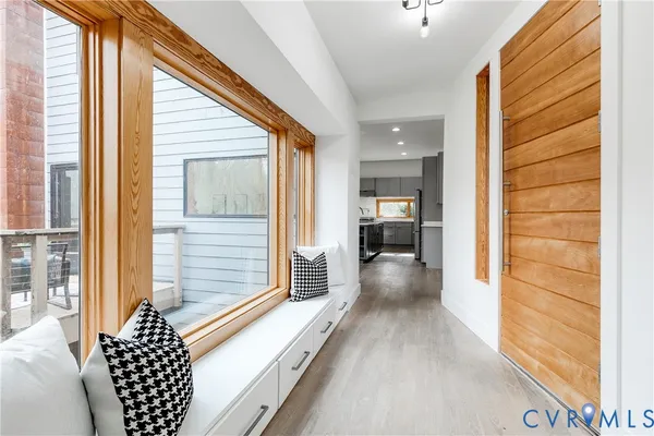 a view of a hallway with wooden floor and windows