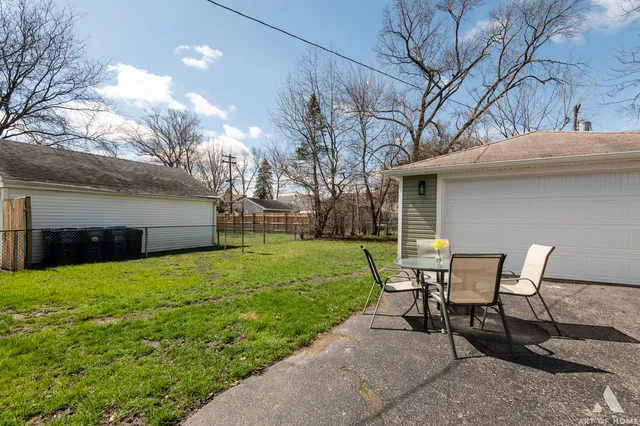 a backyard of a house with table and chairs