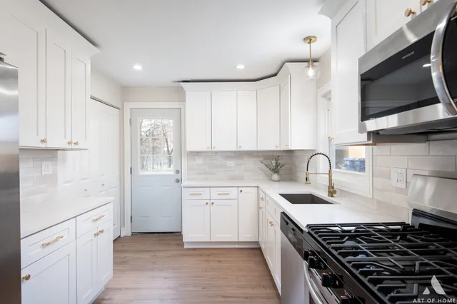 a kitchen with granite countertop a sink stove and cabinets