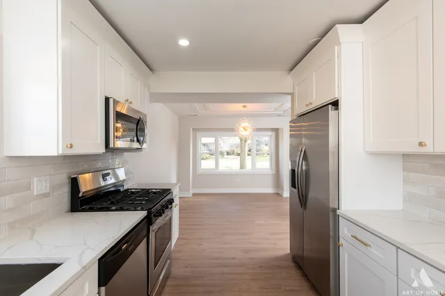 a kitchen with a refrigerator and a stove top oven