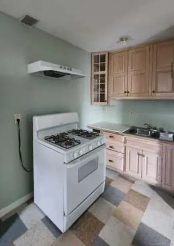 a white stove top oven sitting inside of a kitchen