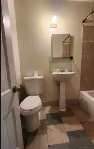a white toilet sitting next to a bathroom sink