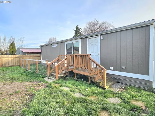 a view of a house with a yard and deck area