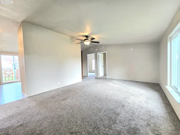a view of a room with a ceiling fan and window