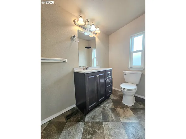 a spacious bathroom with a toilet sink and mirror