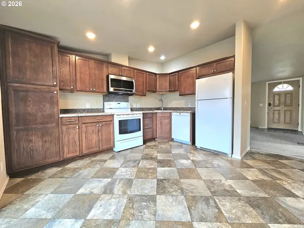 a kitchen with stainless steel appliances granite countertop a refrigerator and a stove