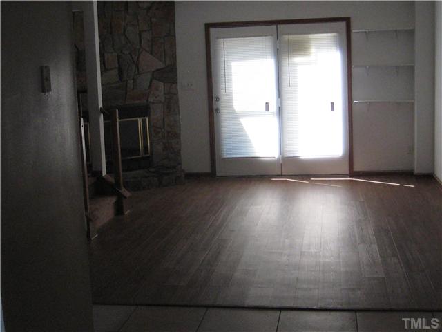 8147 McGuire Drive Raleigh, NC 27616 - Photo 4 of 6 an empty room with wooden floor and windows