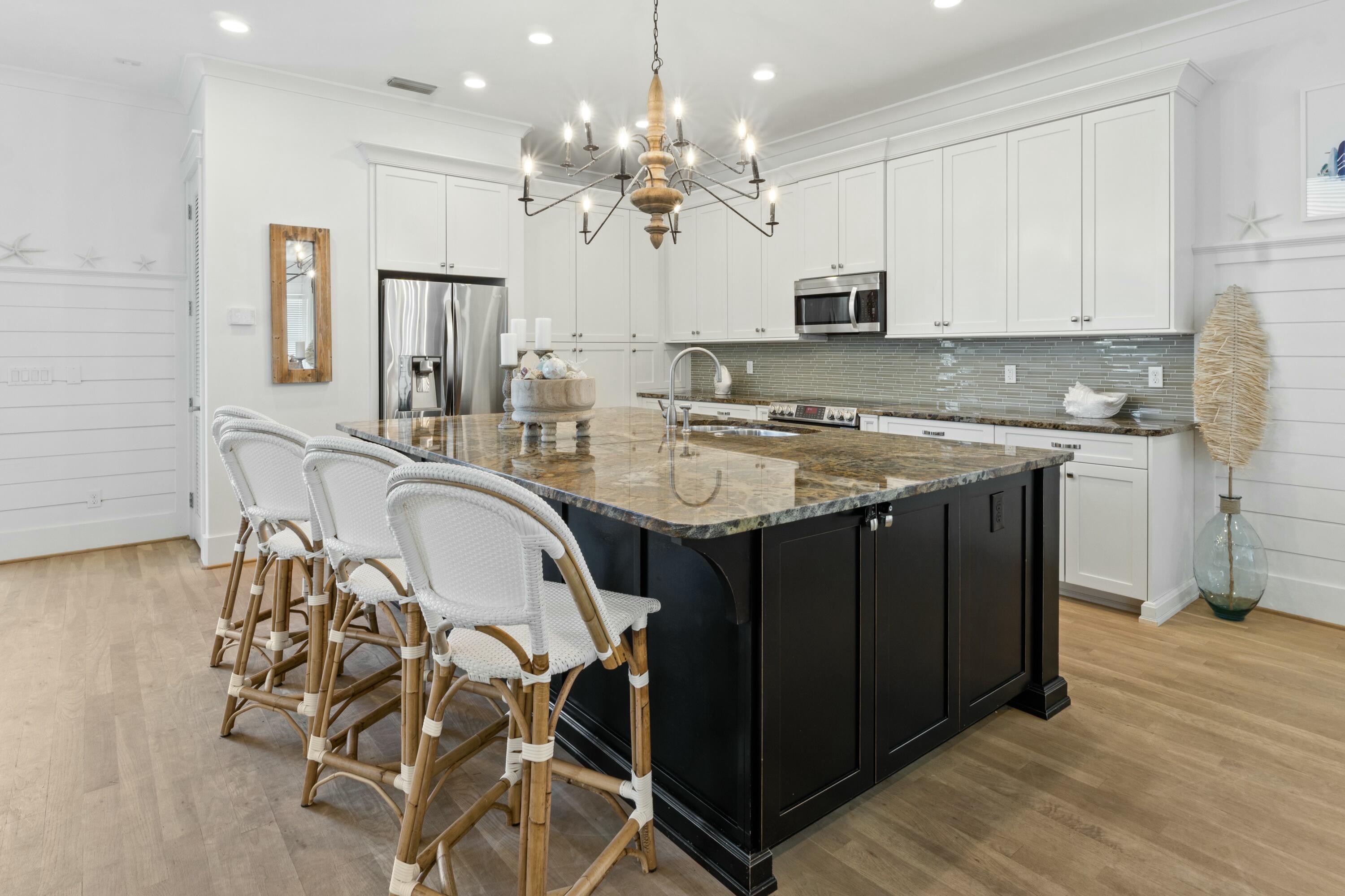125 Gulfview Circle Santa Rosa Beach, FL 32459 - Photo 9 of 57 a kitchen with stainless steel appliances granite countertop a sink a stove a dining table and chairs