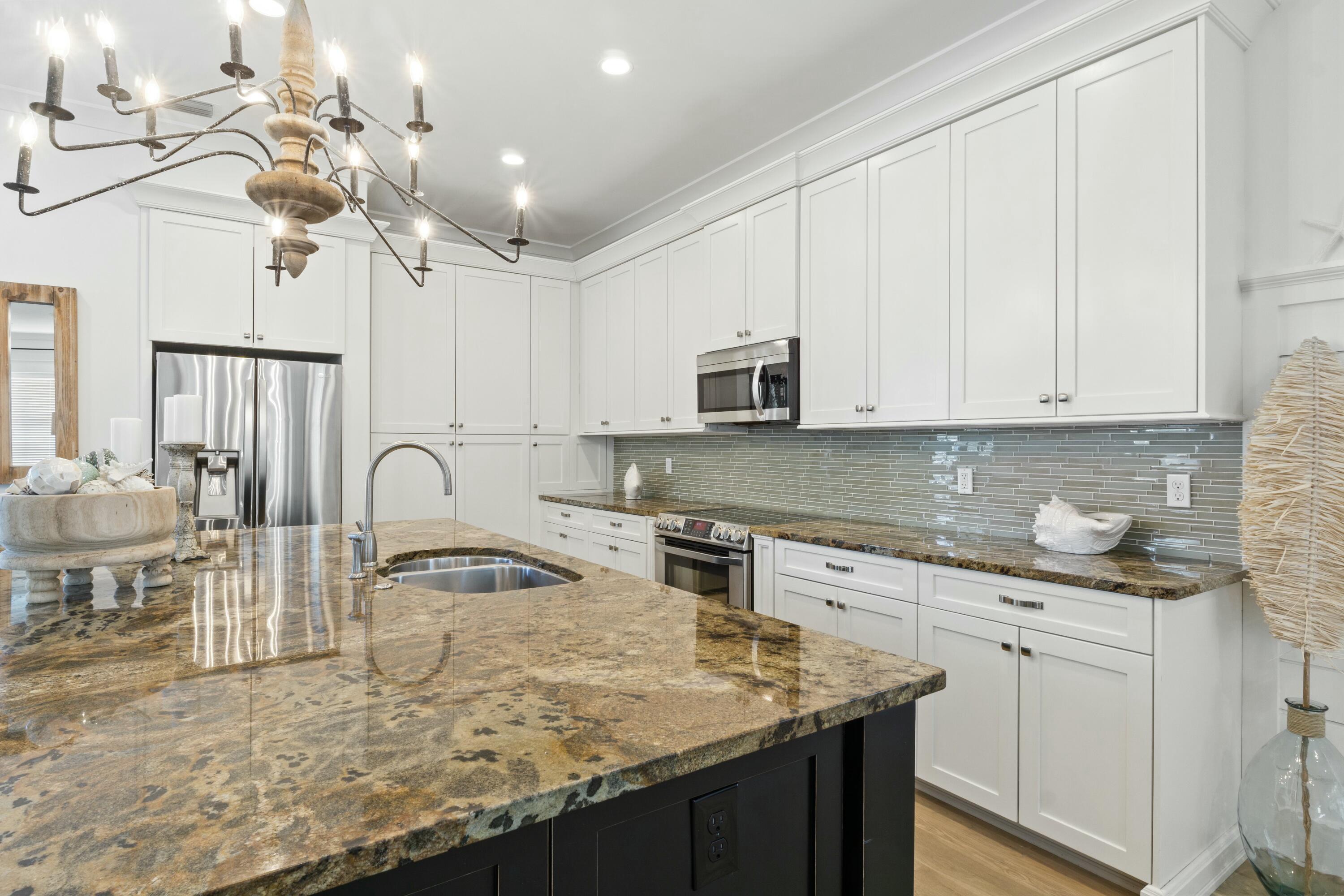 125 Gulfview Circle Santa Rosa Beach, FL 32459 - Photo 10 of 57 a kitchen with kitchen island granite countertop a sink a center island a stove and cabinets