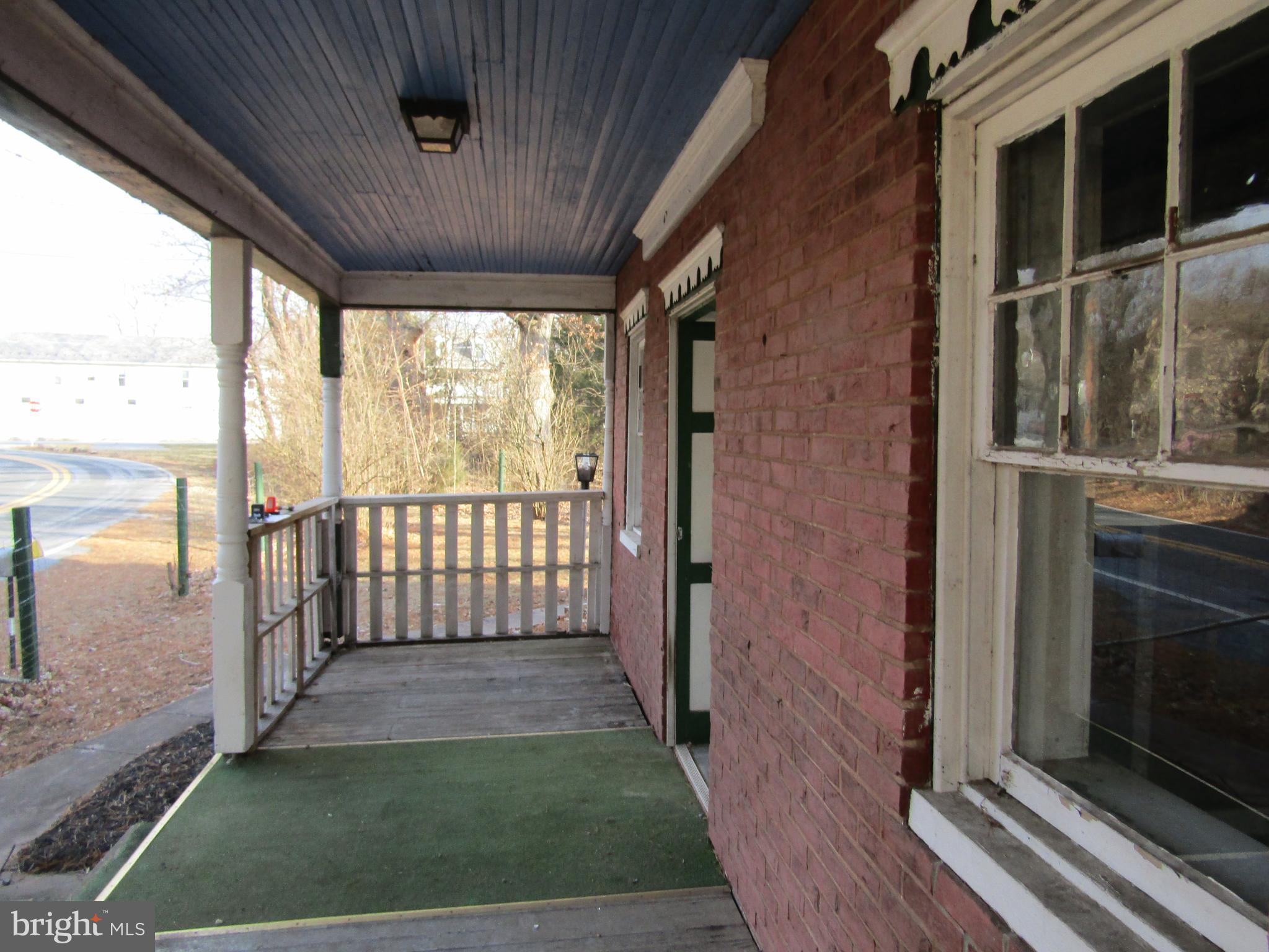 6005 Conover Road Taneytown, MD 21787 - Photo 5 of 30 a view of a porch with wooden floor and a floor to ceiling window