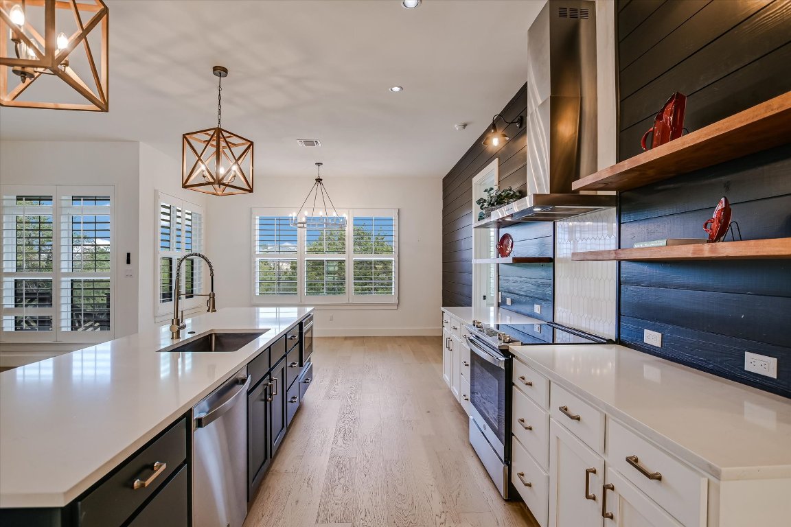 935 Wesley Ridge Drive Spicewood, TX 78669 - Photo 11 of 40 a kitchen with granite countertop a sink counter top space appliances and a window