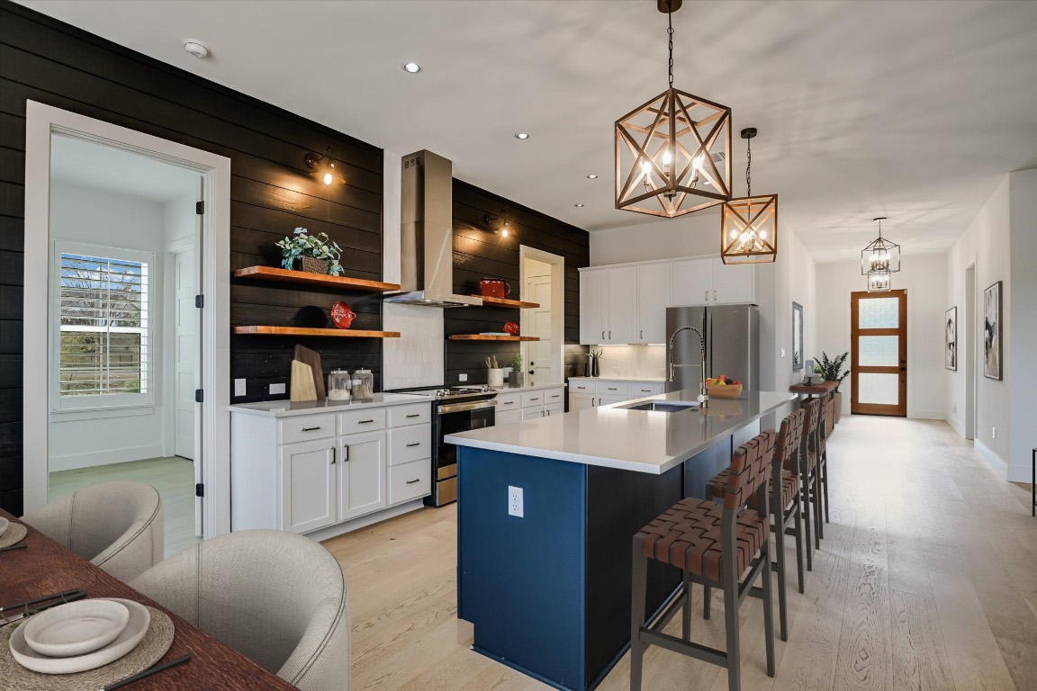 935 Wesley Ridge Drive Spicewood, TX 78669 - Photo 12 of 40 a kitchen with stainless steel appliances granite countertop a sink a stove a dining table and chairs