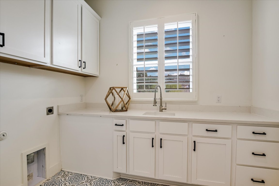 935 Wesley Ridge Drive Spicewood, TX 78669 - Photo 17 of 40 a kitchen with white cabinets and a window