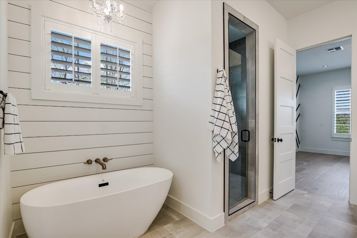 935 Wesley Ridge Drive Spicewood, TX 78669 - Photo 23 of 40 a bathroom with a bathtub and shower