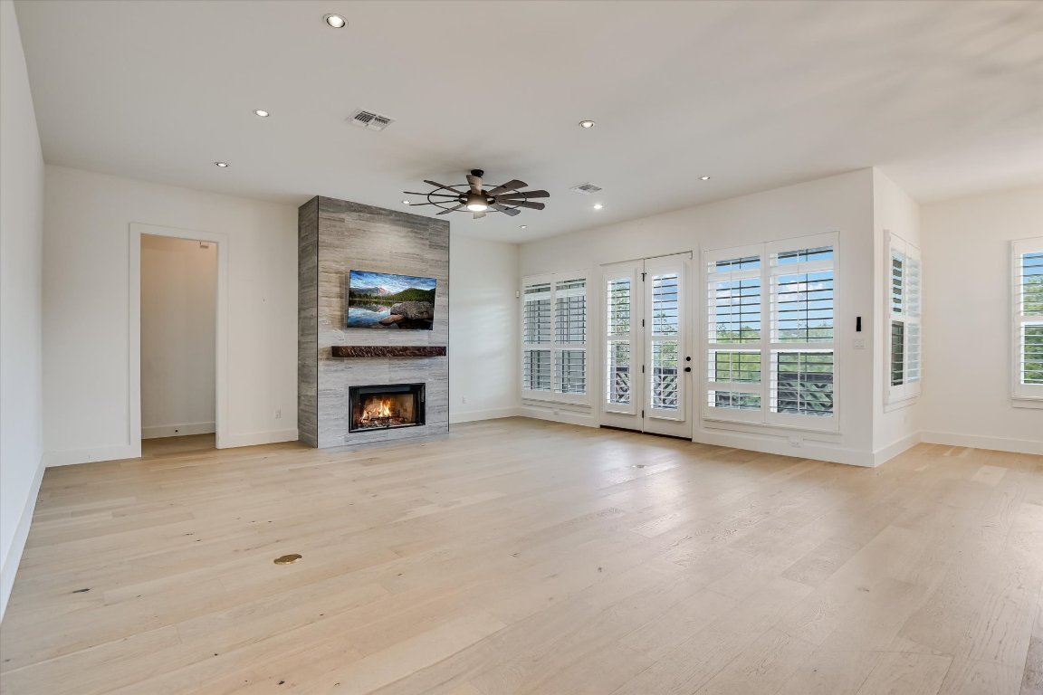 935 Wesley Ridge Drive Spicewood, TX 78669 - Photo 9 of 40 a view of an empty room with a fireplace and a window