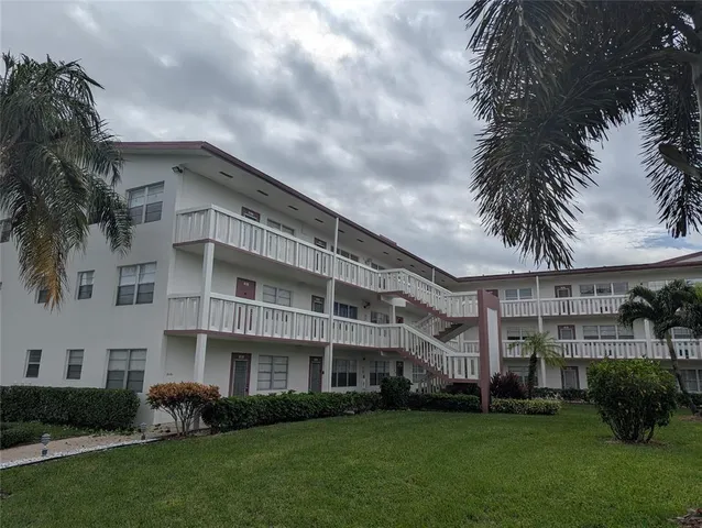 a front view of a building with a garden