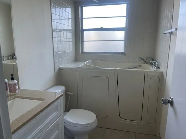 a bathroom with a sink toilet and window