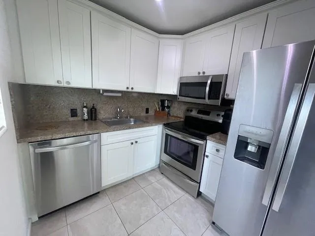 a kitchen with cabinets stainless steel appliances and a sink