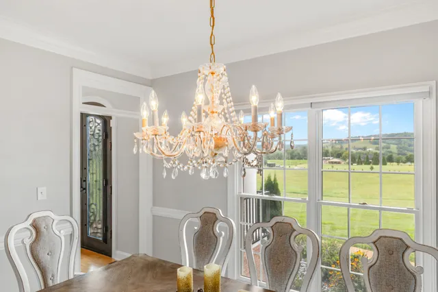 an empty room with windows and chandelier fan
