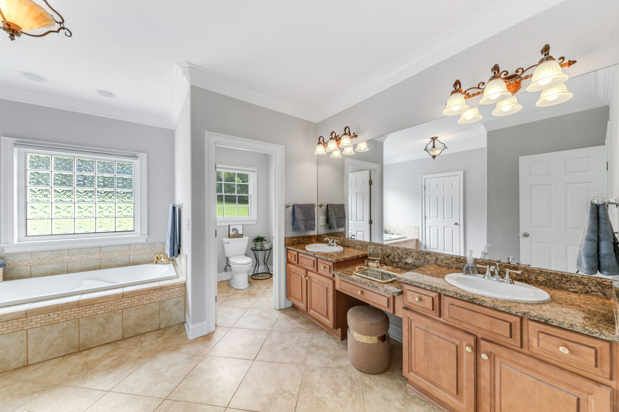 3895 Ostella Road Lewisburg, TN 37091 - Photo 53 of 100 a spacious bathroom with a granite countertop sink a mirror a bathtub and next to a window