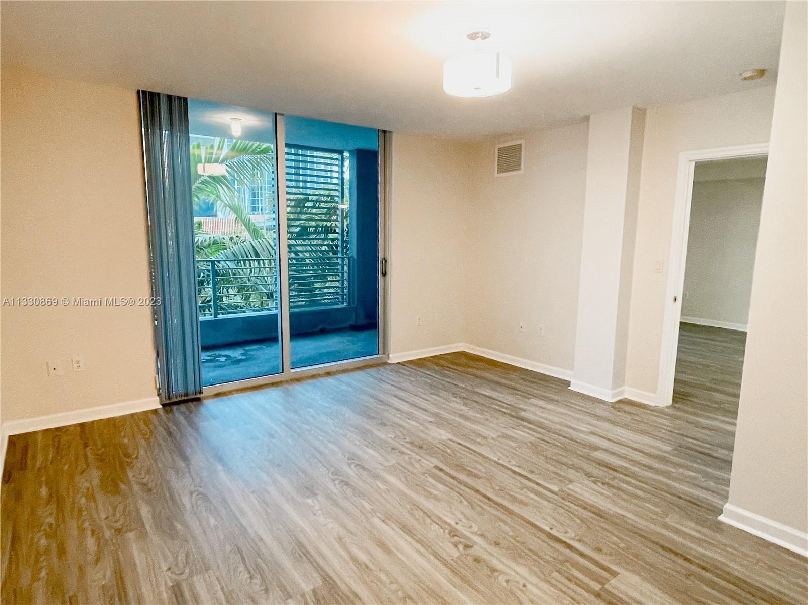 3339 Virginia Street, Unit PH26 Miami, FL 33133 - Photo 13 of 19 a view of an empty room with wooden floor and a window