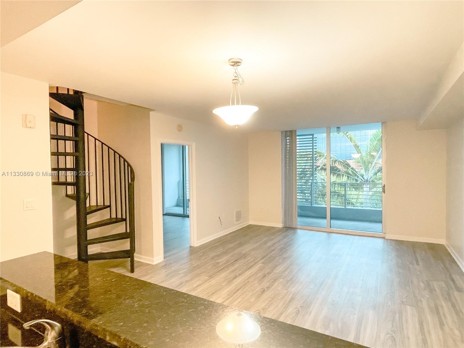 3339 Virginia Street, Unit PH26 Miami, FL 33133 - Photo 14 of 19 a view of an empty room with stairs and a window