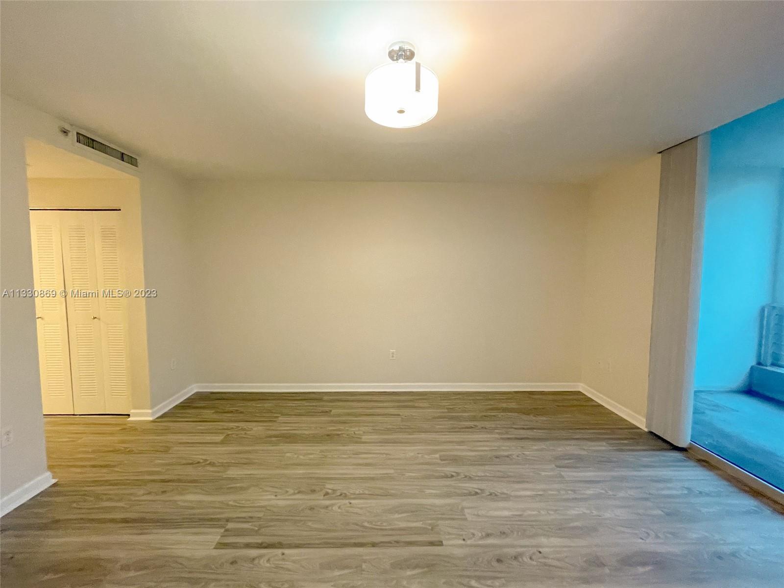 3339 Virginia Street, Unit PH26 Miami, FL 33133 - Photo 17 of 19 a view of an empty room with wooden floor and a window