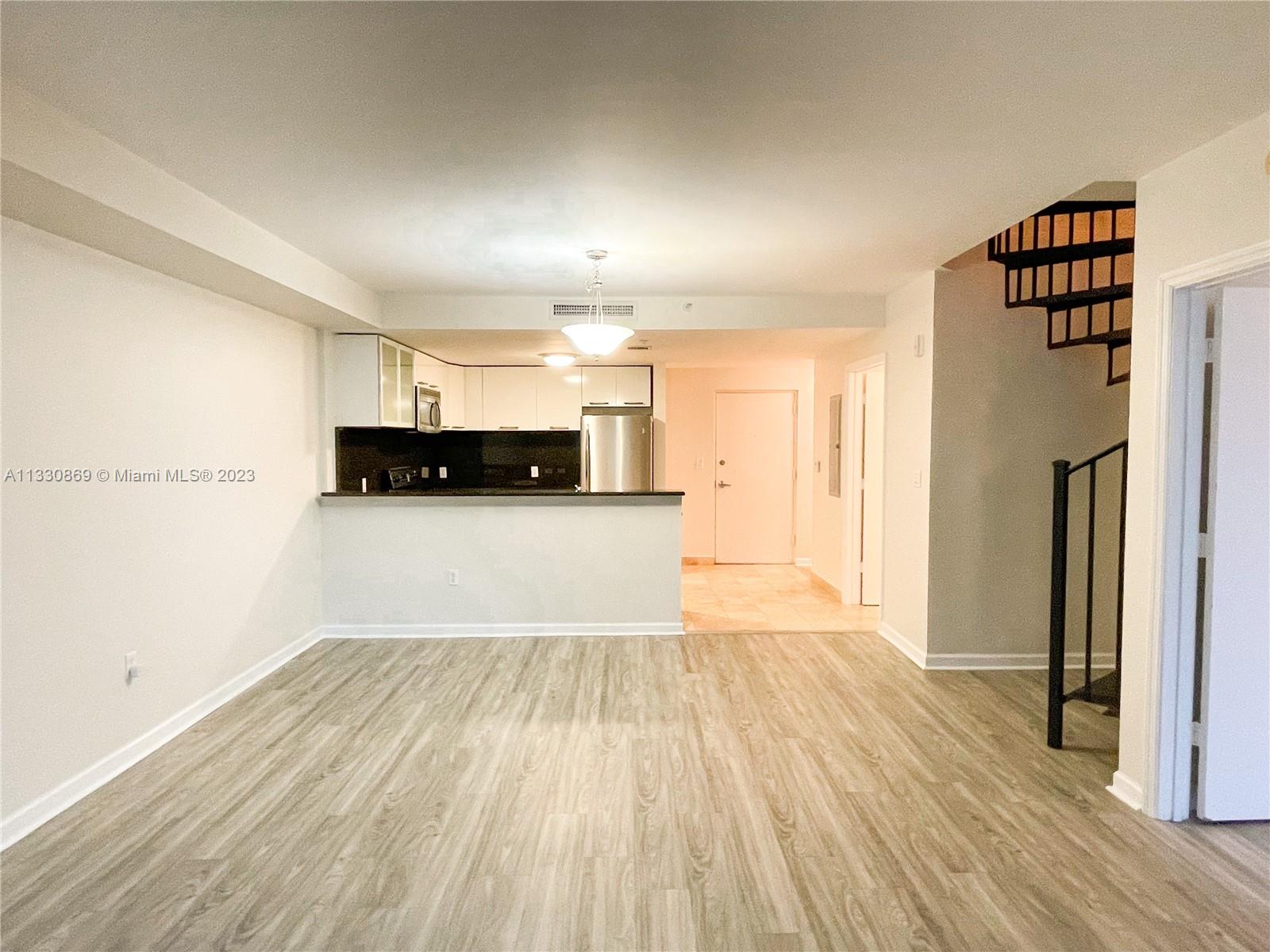 3339 Virginia Street, Unit PH26 Miami, FL 33133 - Photo 5 of 19 a view of a kitchen with a sink and a refrigerator