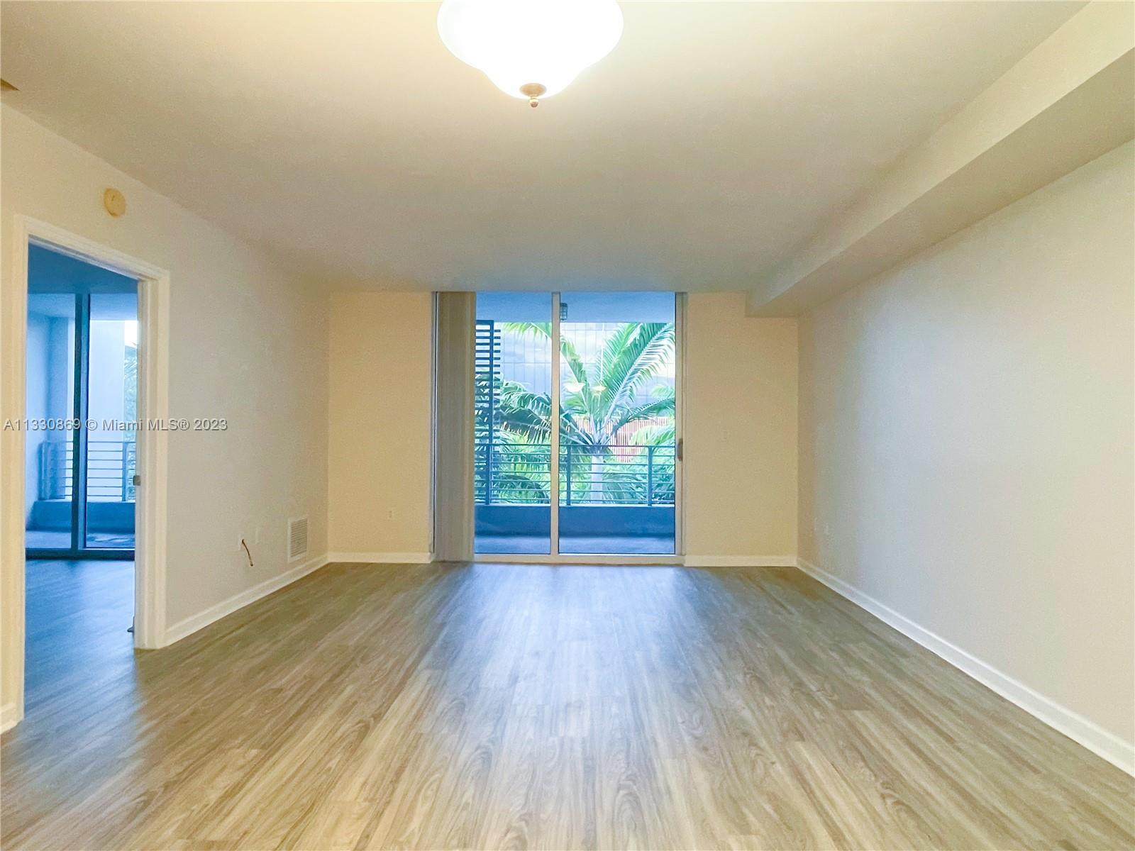 3339 Virginia Street, Unit PH26 Miami, FL 33133 - Photo 10 of 19 a view of an empty room with wooden floor and a window