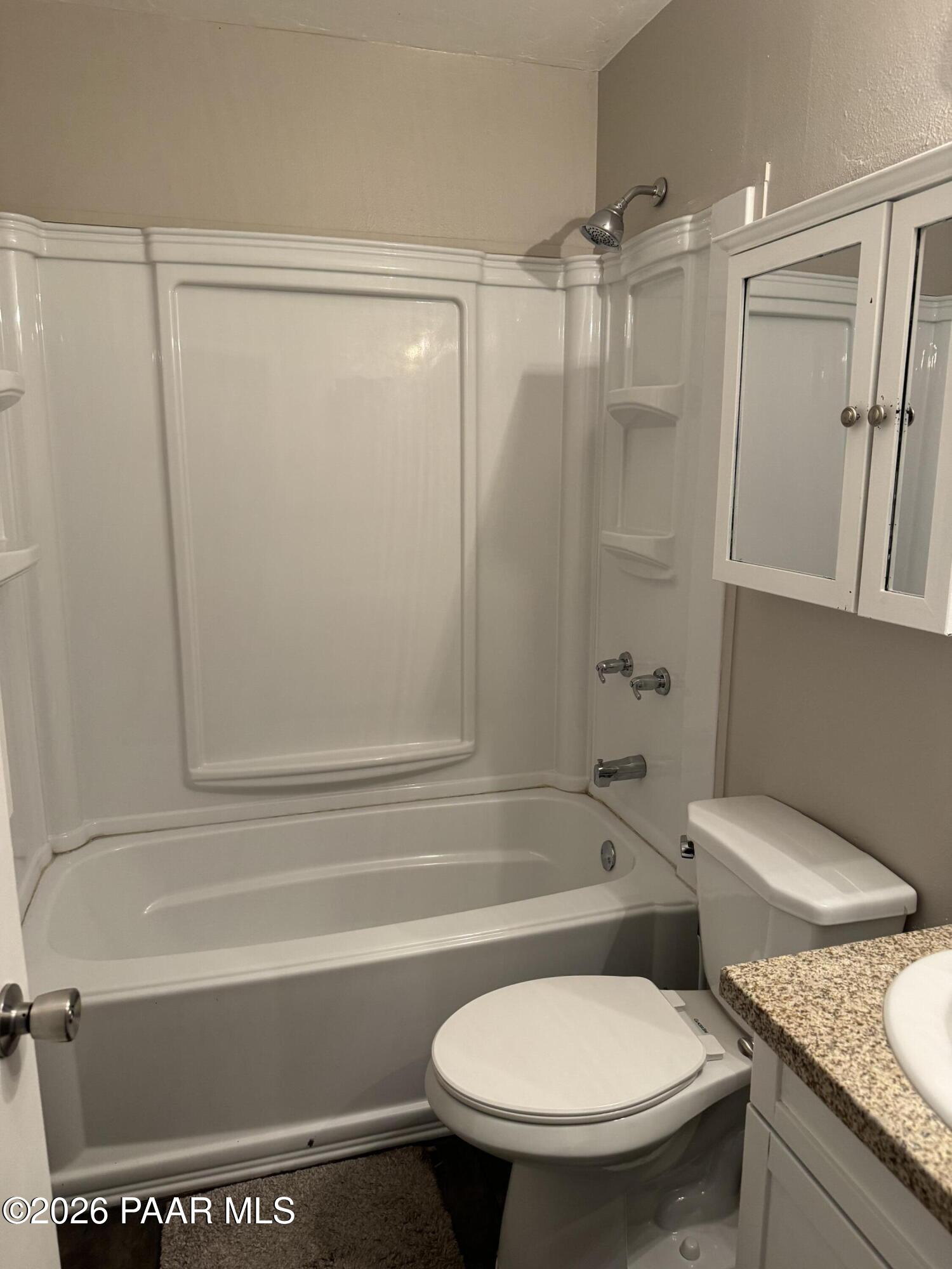 845 Sunset Avenue, Unit D Prescott, AZ 86305 - Photo 3 of 10 a bathroom with a granite countertop toilet sink and shower