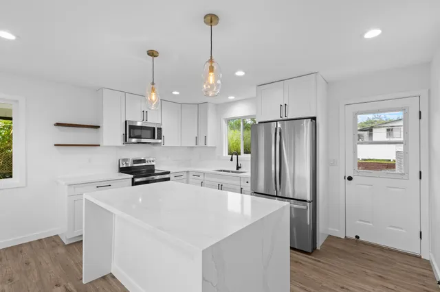 a kitchen with stainless steel appliances a refrigerator sink and microwave