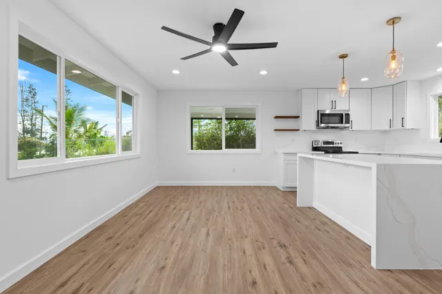 a kitchen with wooden floors and white cabinets