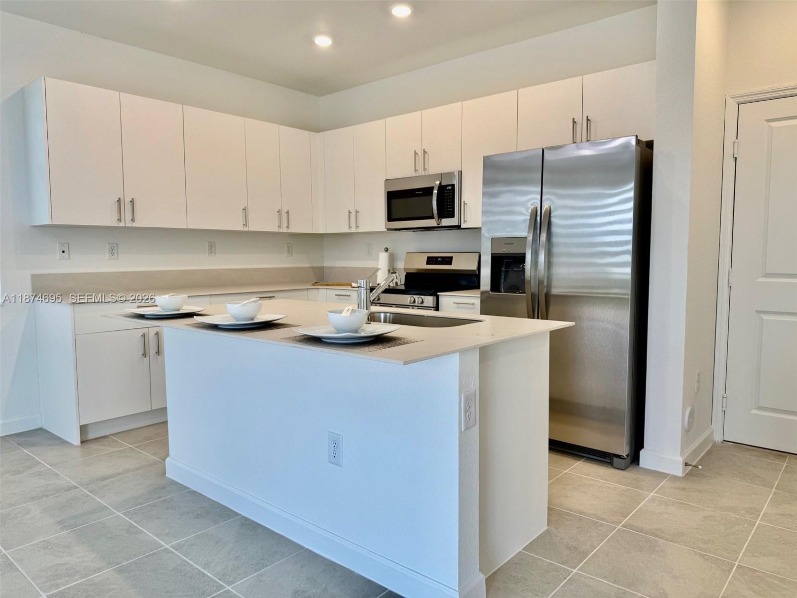 2600 Southeast 25th Street Homestead, FL 33035 - Photo 23 of 61 a kitchen with a refrigerator a stove a microwave and cabinets