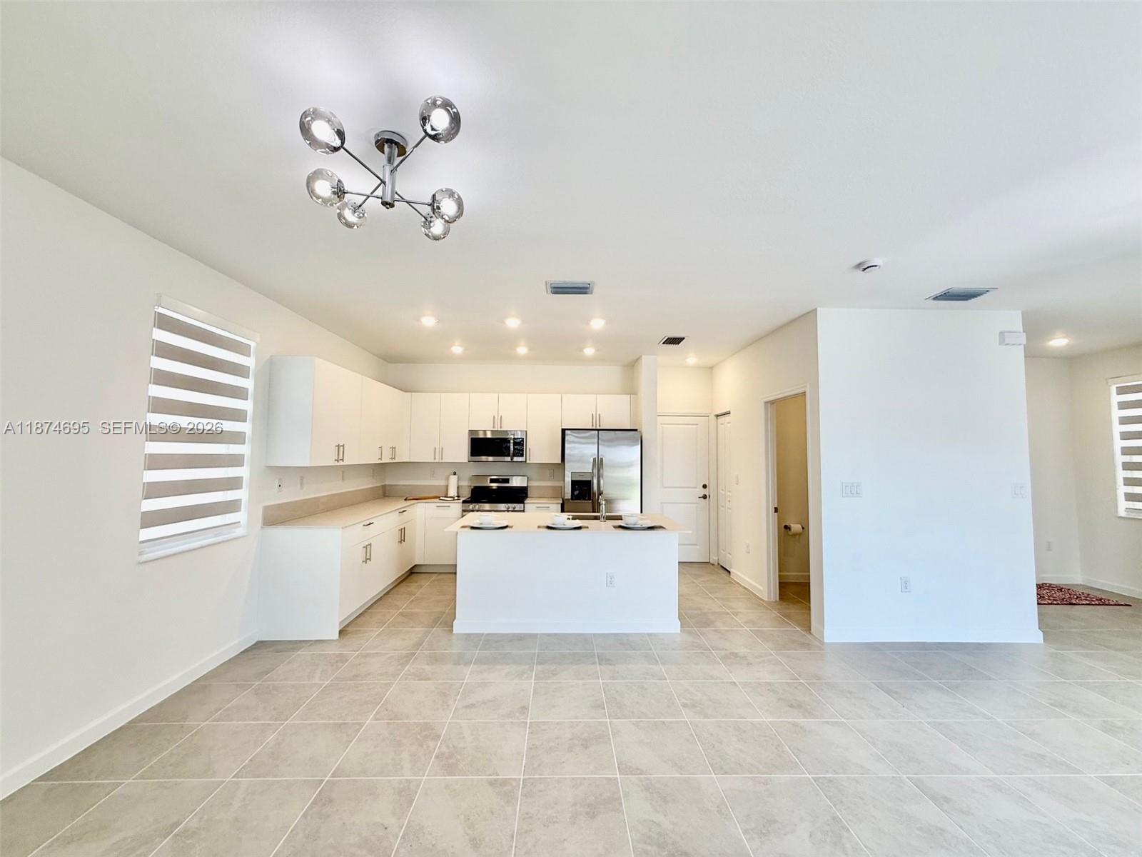 2600 Southeast 25th Street Homestead, FL 33035 - Photo 29 of 61 a view of a kitchen with kitchen island stainless steel appliances refrigerator stove a sink dishwasher with a dining table and chairs
