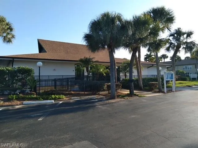 a row of palm trees in front of a building