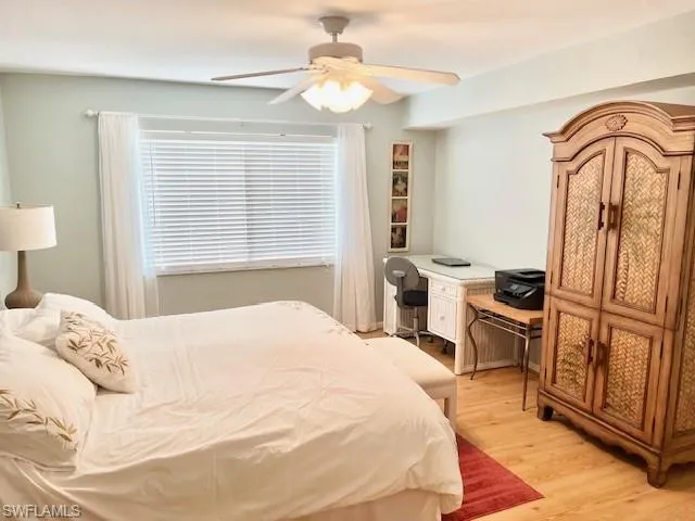 a bedroom with a bed a dresser and flat screen tv