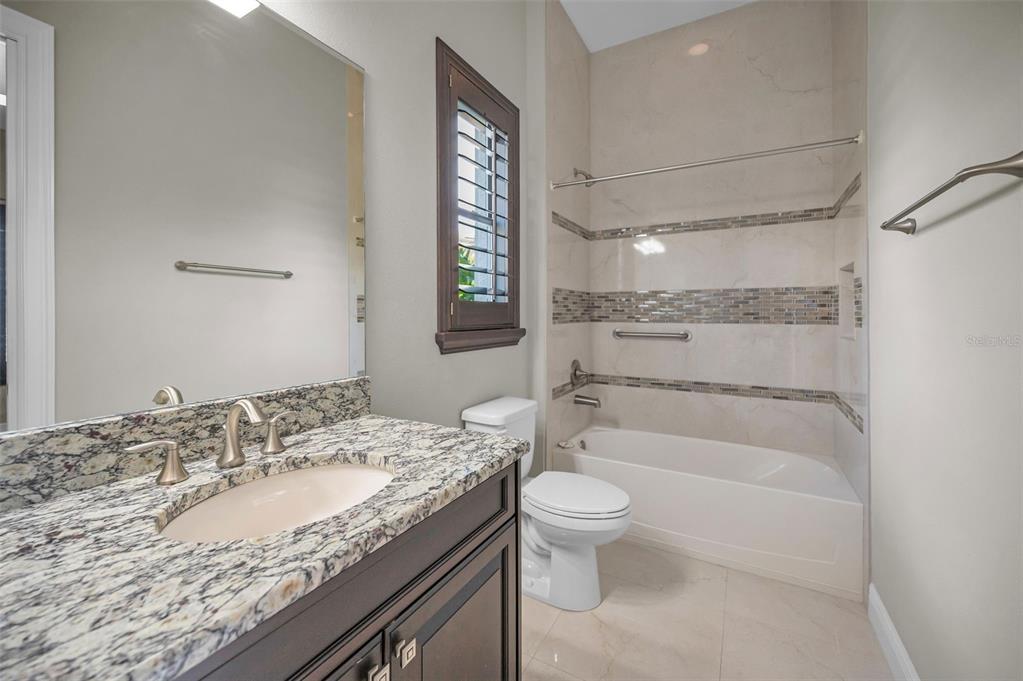 9829 Milano Drive Trinity, FL 34655 - Photo 66 of 100 a bathroom with a granite countertop sink a toilet and shower