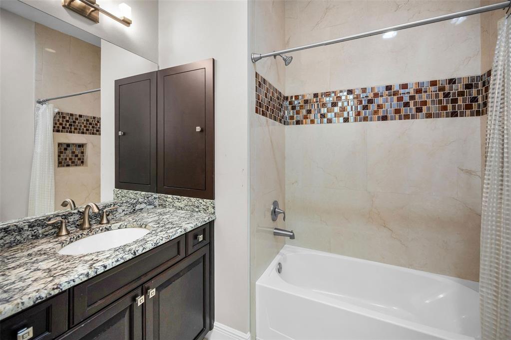 9829 Milano Drive Trinity, FL 34655 - Photo 74 of 100 a bathroom with a granite countertop sink and a shower