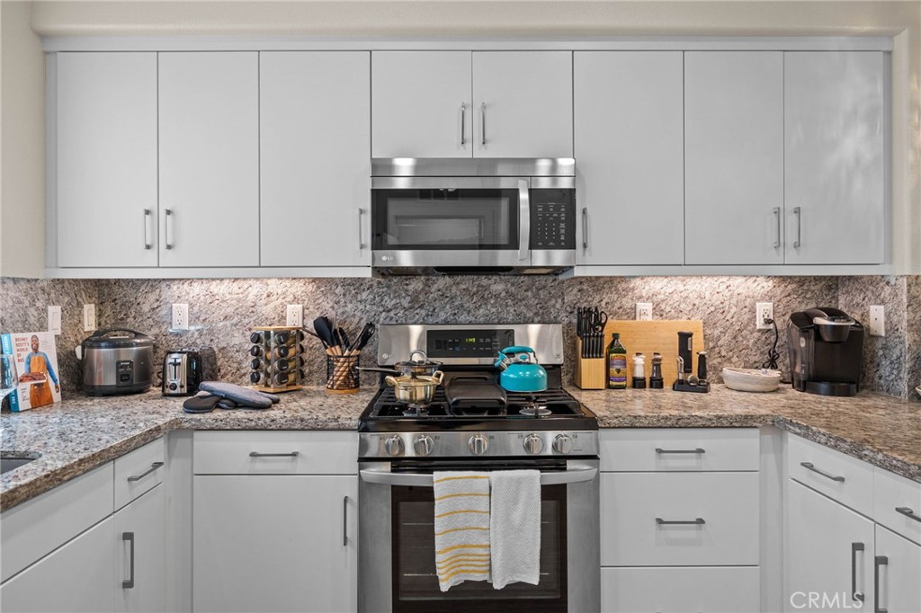 9040 Garvey Avenue, Unit 5 Rosemead, CA 91770 - Photo 18 of 33 a kitchen with granite countertop white cabinets and a stove