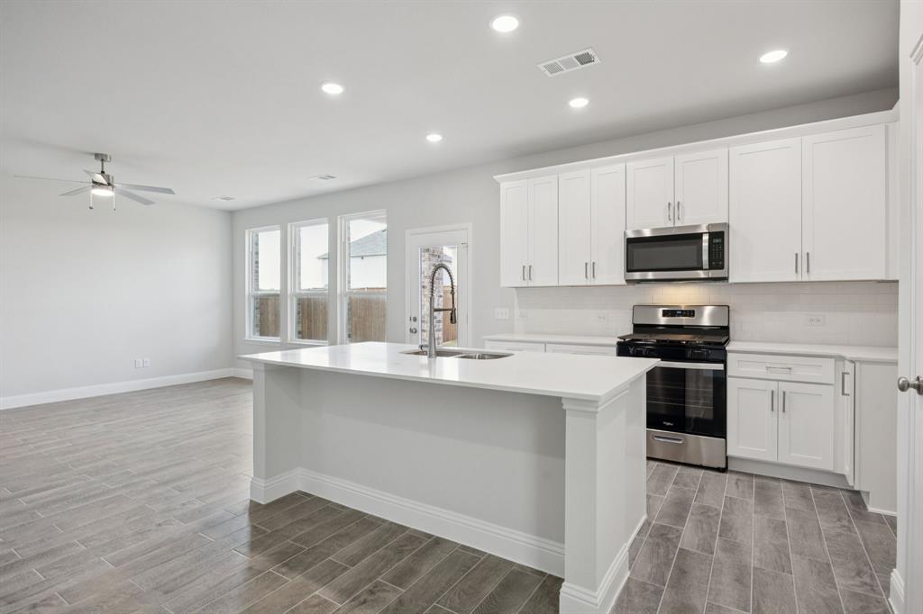 529 Magellan Road Seagoville, TX 75159 - Photo 5 of 37 a kitchen with a sink cabinets and stainless steel appliances