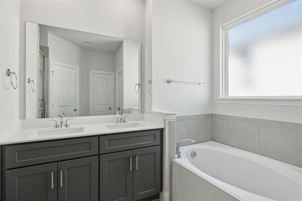 529 Magellan Road Seagoville, TX 75159 - Photo 10 of 37 a bathroom with a tub a sink and mirror