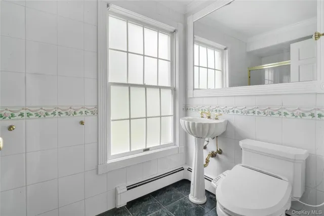 a bathroom with a sink a toilet and mirror