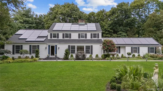 a front view of a house with a garden and trees