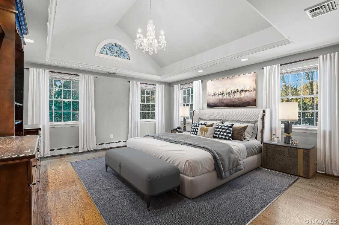 51 Bay Road Huntington Bay, NY 11743 - Photo 22 of 42 a bedroom with a large bed and a chandelier