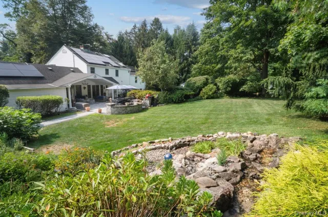 a view of a patio with table and chairs potted plants with a barbeque grill and plants