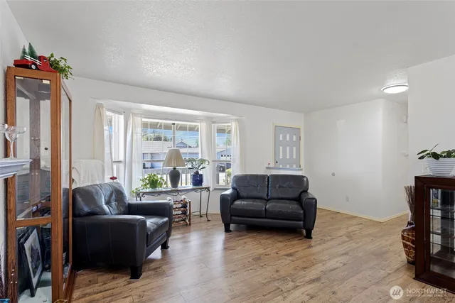 a living room with furniture fireplace and a large window