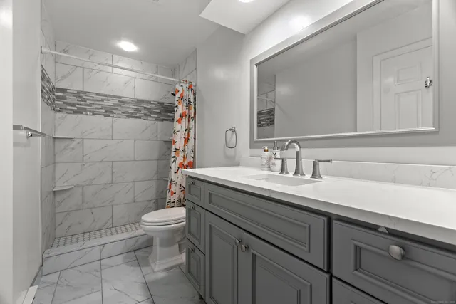 a bathroom with a sink toilet and shower