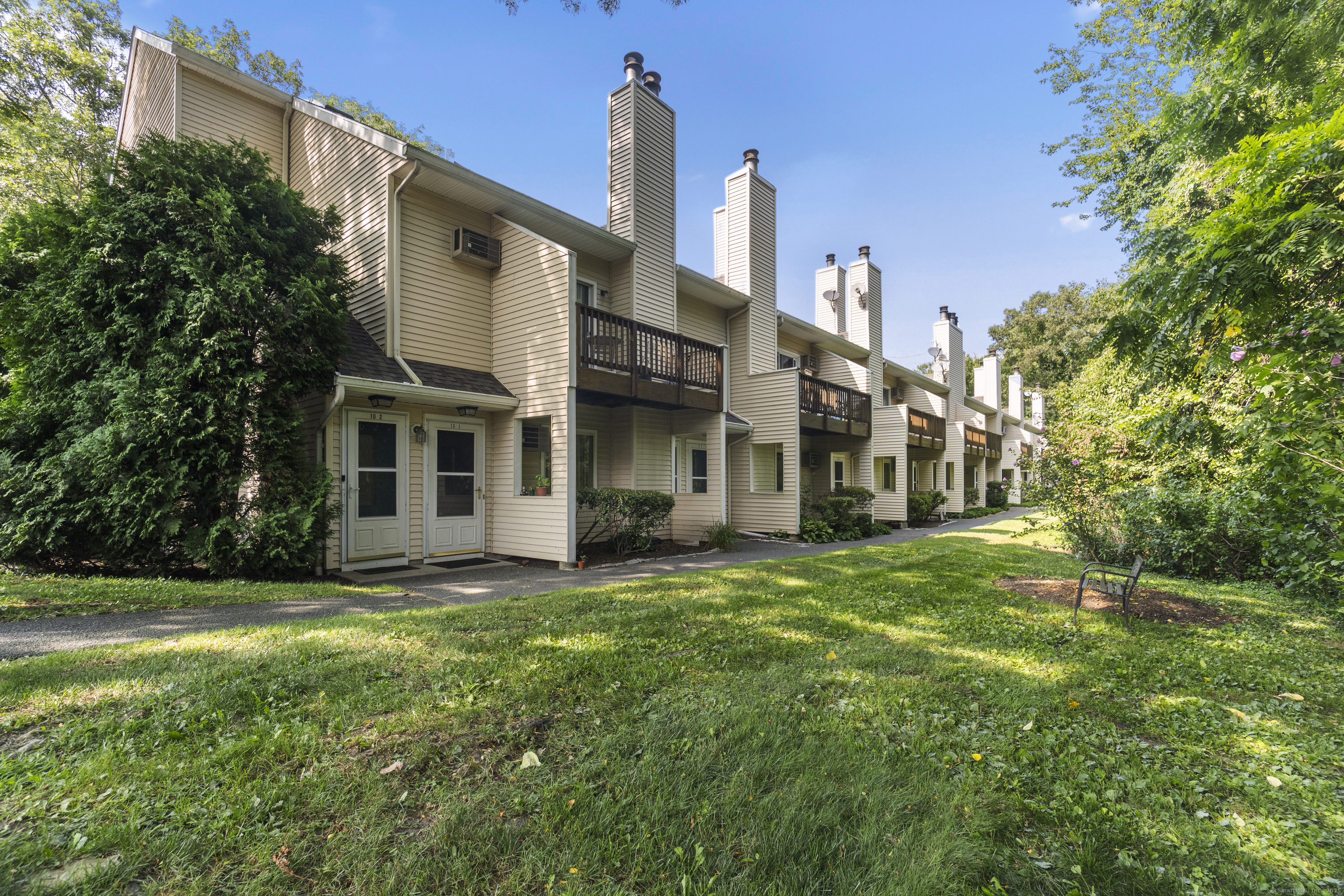 8 Rose Lane, Unit 105 Danbury, CT 06811 - Photo 18 of 20 a view of a white house with a big yard and large trees