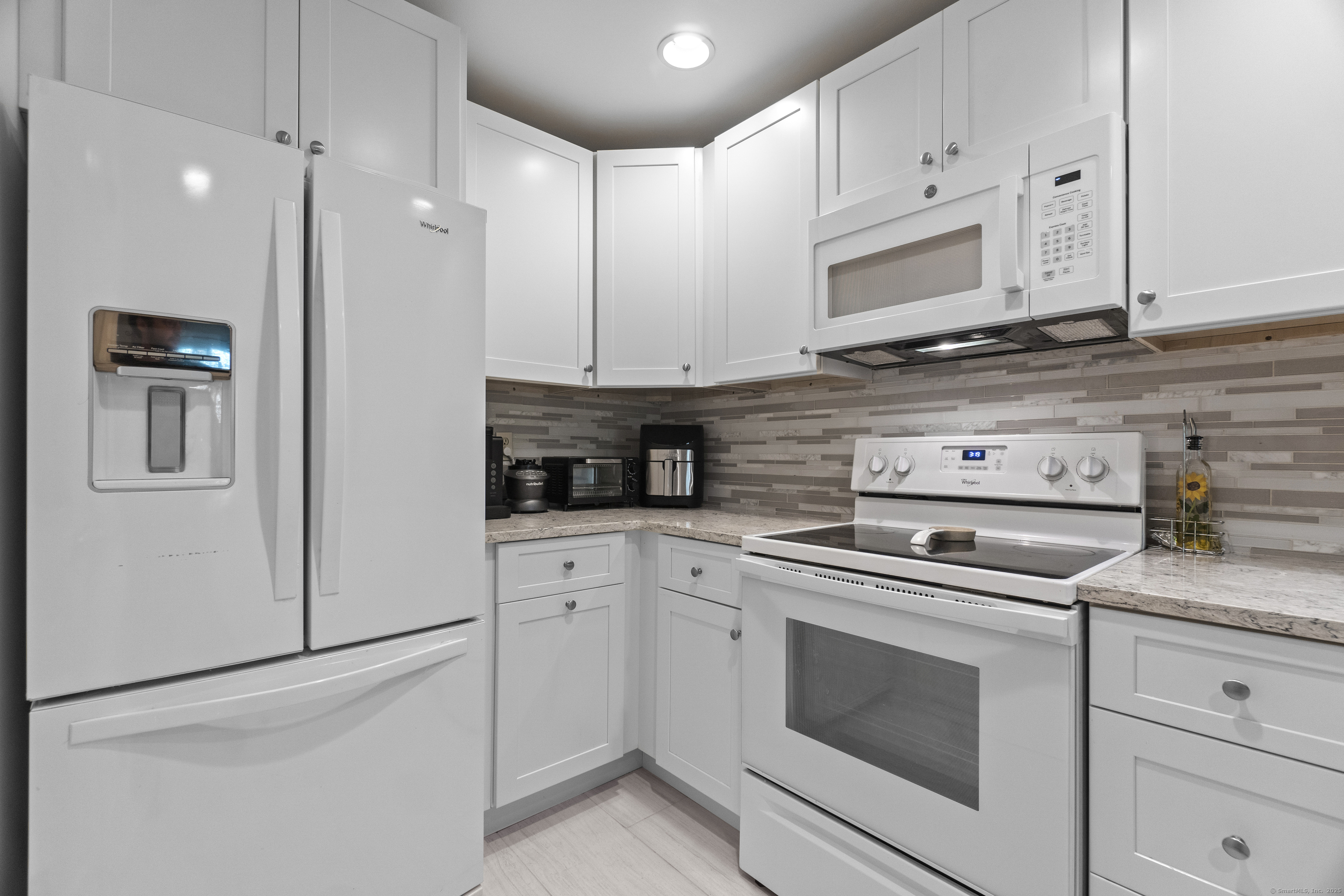 8 Rose Lane, Unit 105 Danbury, CT 06811 - Photo 6 of 20 a kitchen with stainless steel appliances granite countertop white cabinets and stove a refrigerator with white cabinets