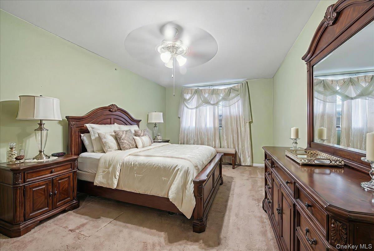 2715 Dewitt Place Bronx, NY 10469 - Photo 4 of 12 a spacious bedroom with a bed and a chandelier